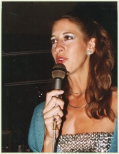 A woman holding a microphone and wearing a dress