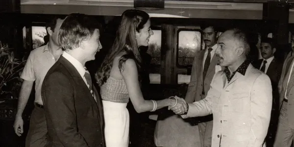 A woman shaking hands with two men.