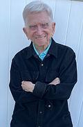 A man with his arms crossed wearing a black shirt.